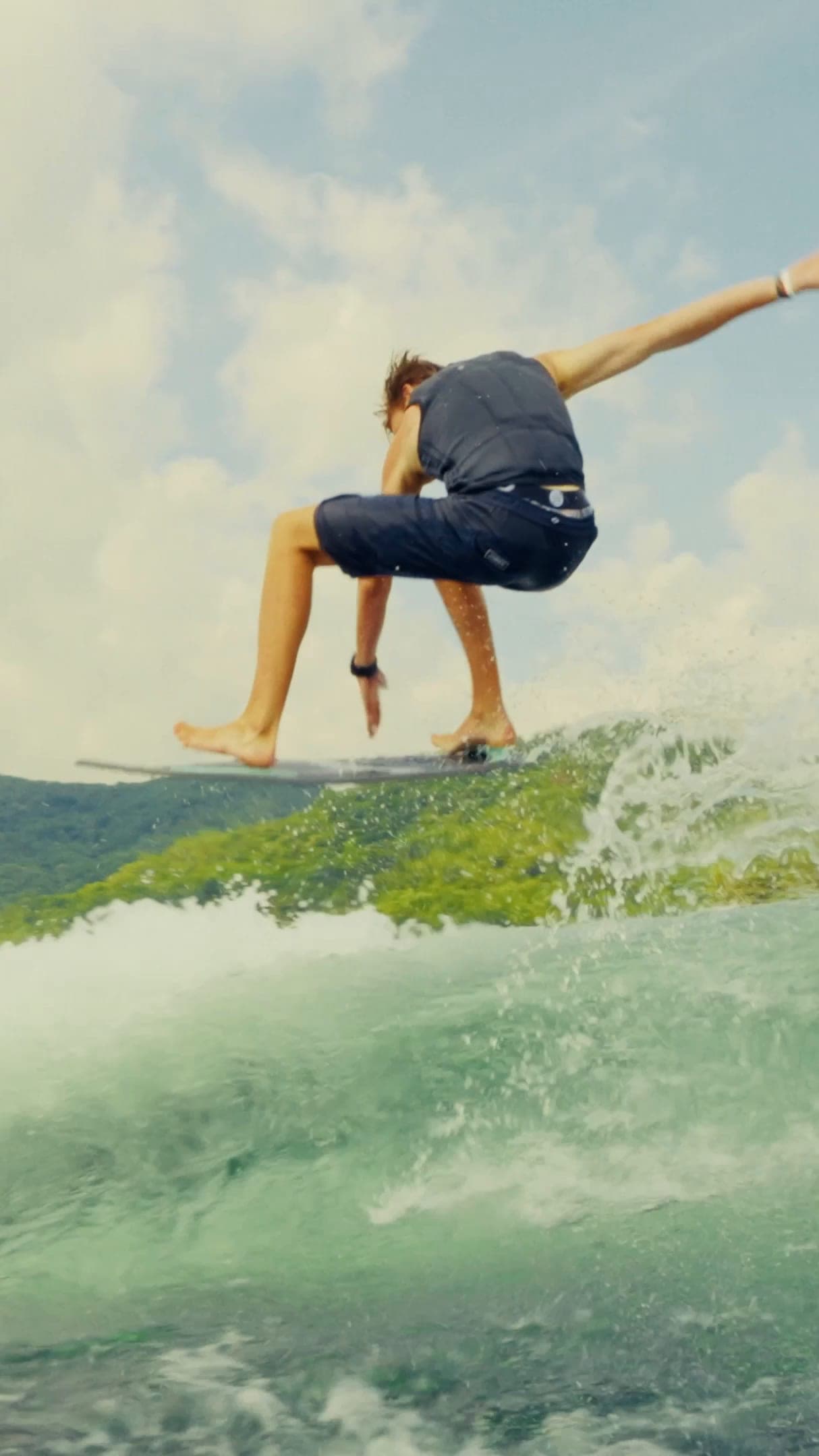 A rider surfs the wave behind a Malibu M Series boat, then the boat rests on calm water in the late sun