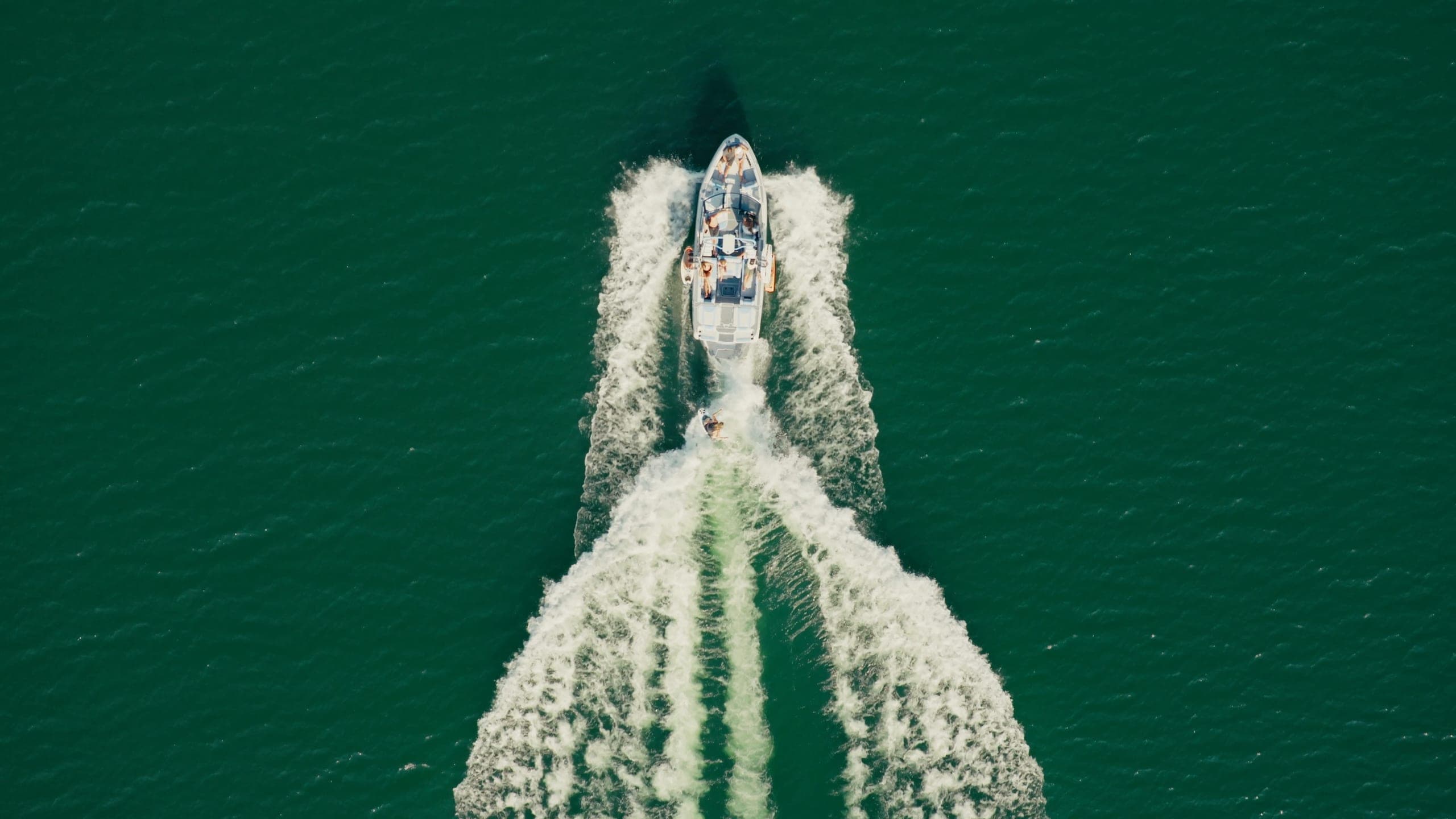 A Malibu 25 LSV seen from directly above, a rider surfing the wave between the two wakes